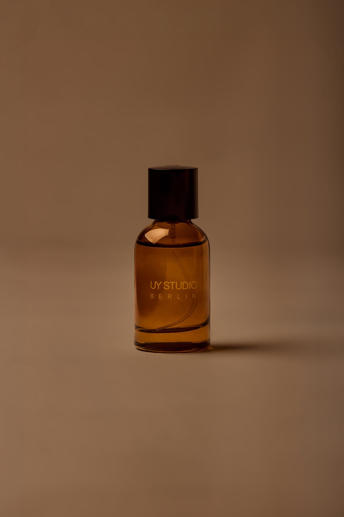 UY Studio T unisex eau de parfum, 50 ml amber glass bottle with engraved logo and black cap, rose, cedar, black tea, musk