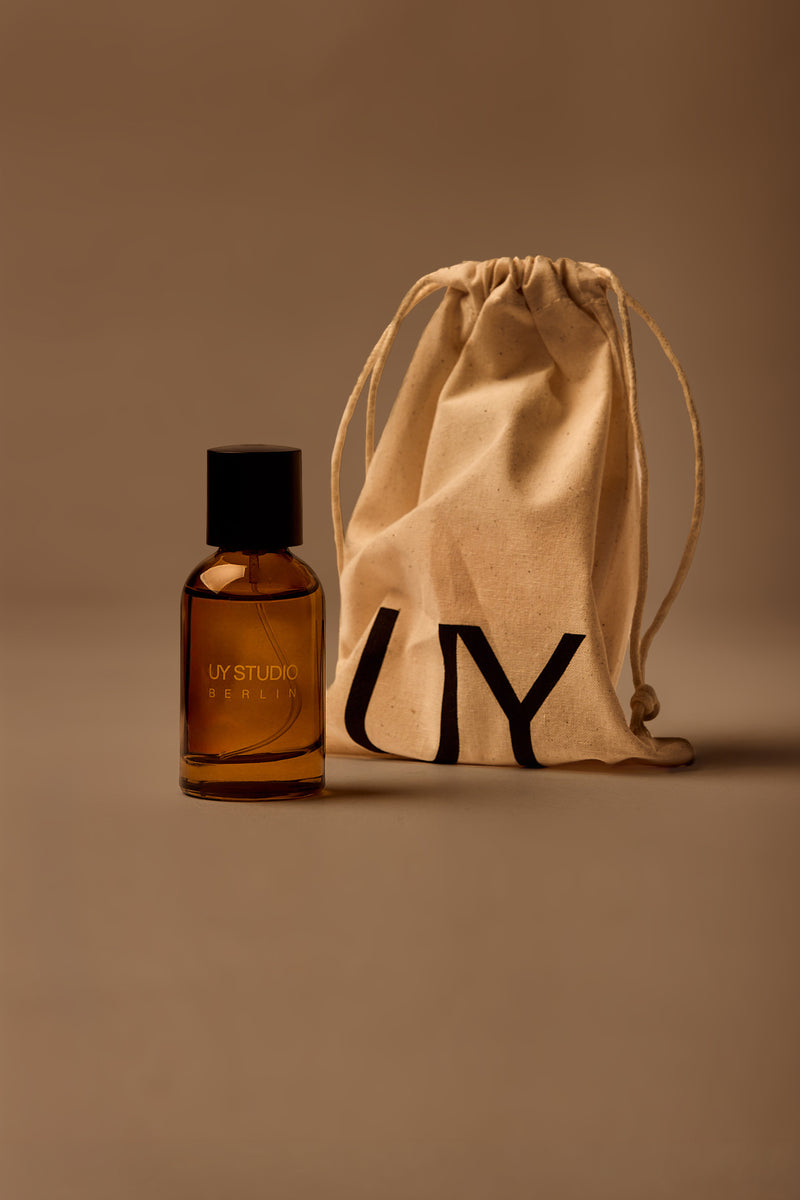 UY Studio S unisex eau de parfum, 50 ml amber glass bottle with engraved logo and black cap, bergamoit, rose, cardamom, jasmine, amber
